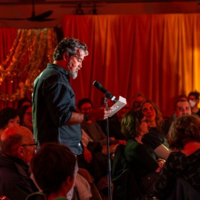 An image of a man reading an apology into a mic