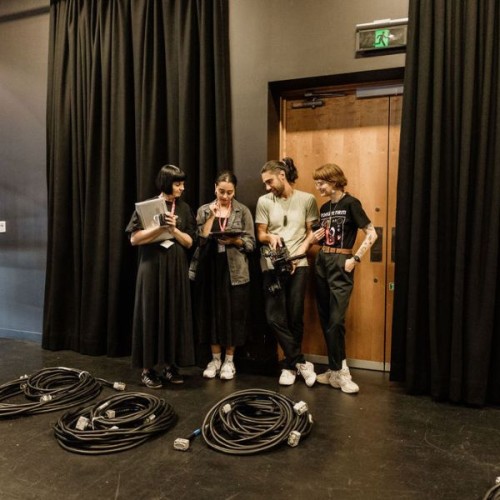 A group of people standing in Q Theatre