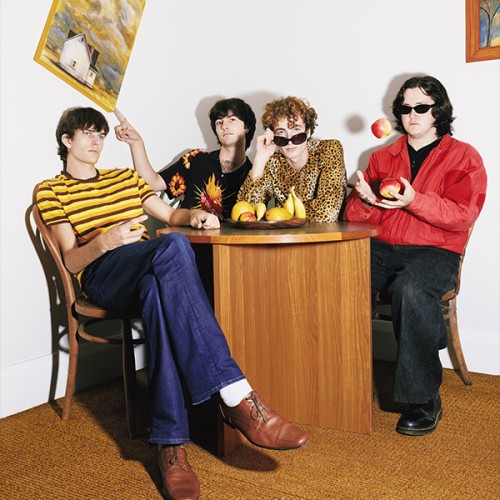 An image of the band borderline sitting round a round table wearing bright colours